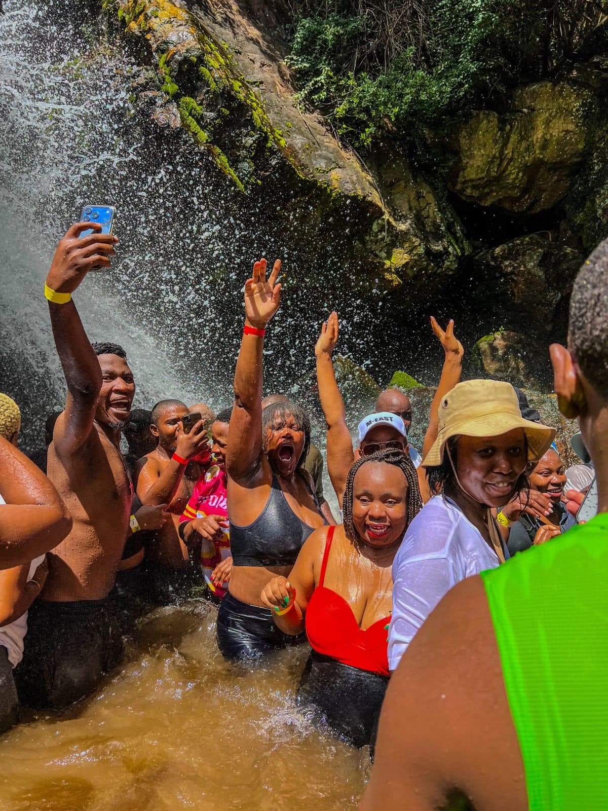 Club members celebrating under a waterfall
