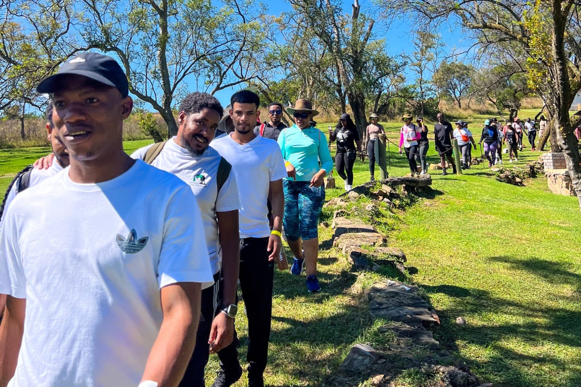 Pretoria Hiking Club members walking a grassy trail on a sunny day