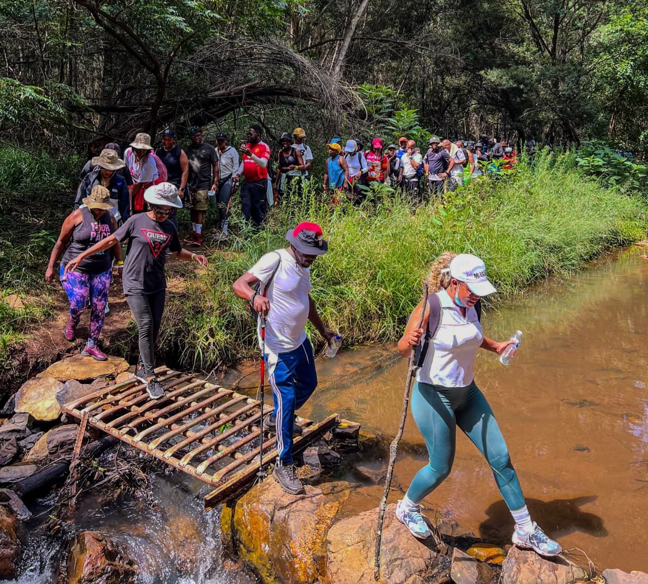 Pretoria Hiking Club members crossing a forest stream on a hike
